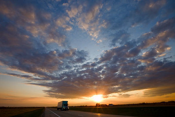 Photo of Truck passing by on highway during a glorious sunset