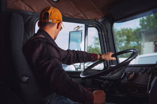 Trucker in His 40s Inside Vintage Aged Semi Truck Tractor Cabin Caucasian Trucker in His 40s Inside Vintage Aged Semi Truck Tractor Cabin. Transportation Industry. truck driver stock pictures, royalty-free photos & images
