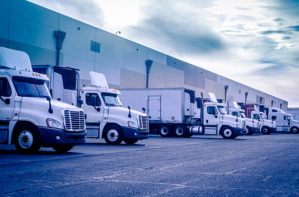 Trucks loading unloading at warehouse Trucks loading unloading at warehouse logistics transportation concept image trucking stock pictures, royalty-free photos & images