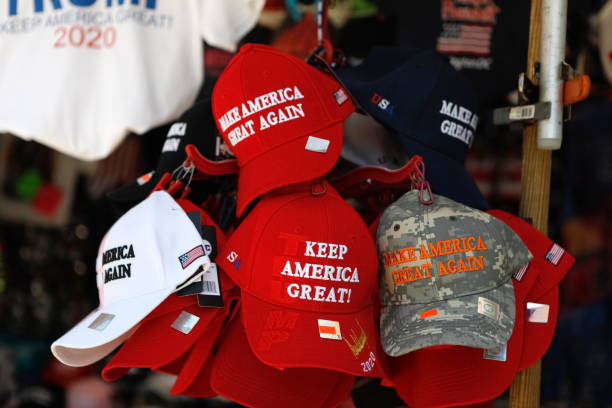 Trump MAGA hats and Reelection gear Washington, D.C., USA - July 21, 2019: A street vendor selling public domain Donald Trump paraphernalia and souvenirs. The souvenirs are located right across the street from the White House and taken on the afternoon of July 21, 2019 near Pennslyvania Avenue in Washington, D.C. The red hat is a signature symbol of his "brand". Donald Trump for President "Make America Great Again" election photos stock pictures, royalty-free photos & images