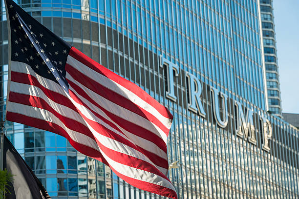 Trump Chicago, USA - August 24, 2016: An American flag flying on the Riverwalk late in the day with the Trump Tower in the background. donald trump stock pictures, royalty-free photos & images