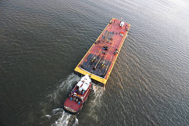 tugboat pushing barge Tugboat pushing a barge up a river. barge stock pictures, royalty-free photos & images