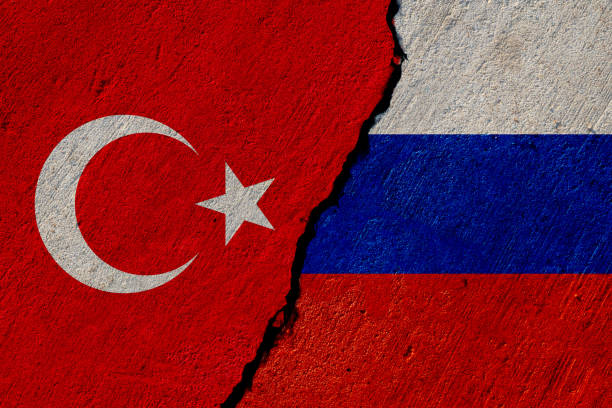 turkish and russian flags painted on cracked concrete wall, turkey and russia conflict or partnership concept stock photo