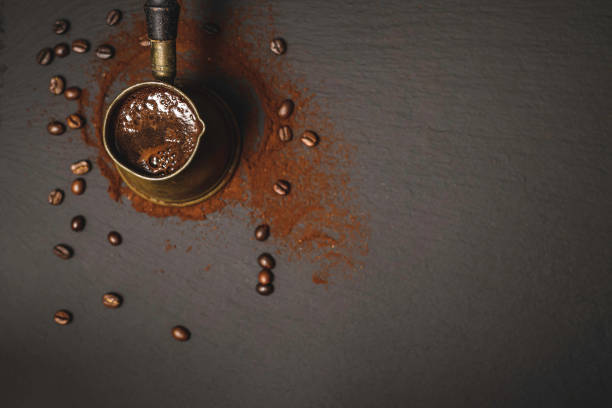 türkische kupfer kaffeekanne mit gerösteten kaffeebohnen - kannestein stock-fotos und bilder