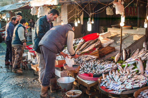 turkse visboer die vis verkoopt aan een klant in istanbul - karaköy istanbul stockfoto's en -beelden
