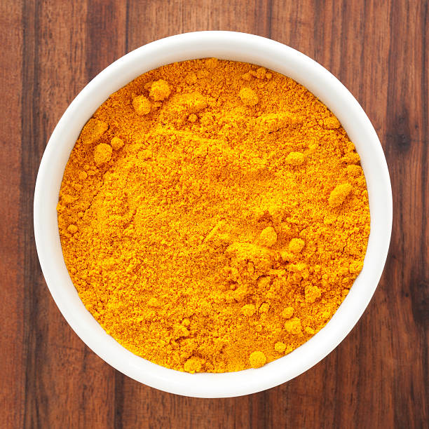 Turmeric Top view of white bowl full of turmeric powder turmeric stock pictures, royalty-free photos & images