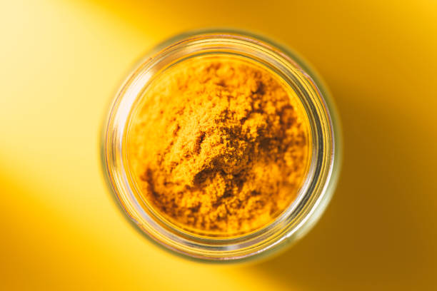 Turmeric powder in glass jar stock photo