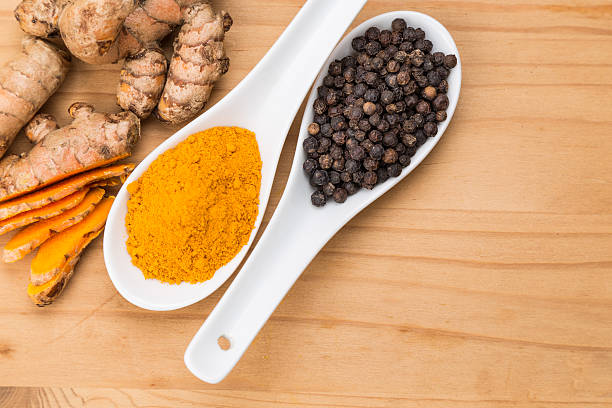 Turmeric roots and black pepper combination enhances curcumin ab Turmeric roots and black pepper combination enhances bioavailability of curcumin absorption in body for health benefits turmeric stock pictures, royalty-free photos & images