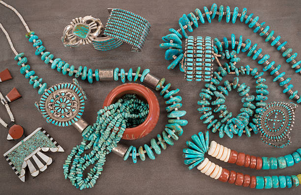 Turquoise Jewelry Extravaganza. A collection of Vintage Native American Jewelry made of turquoise, silver, pipe stone and Heishe beads. A Santo Domingo “Depression Era” Necklace, and Turquoise "Nugget" necklaces with silver beads, and Zuni and Navajo "Cuff" Bracelets, on a Grey Slate Background. indian jewelry stock pictures, royalty-free photos & images