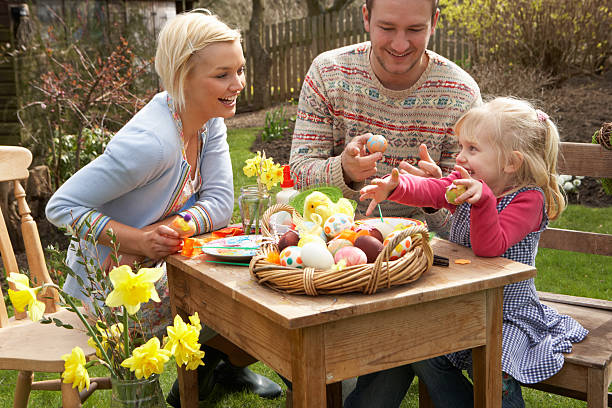Two adults and a child outside with Easter eggs stock photo