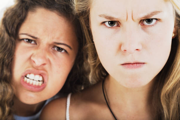Two angry young women snarl in fury Pair of women rage at the camera. ugly girl stock pictures, royalty-free photos & images