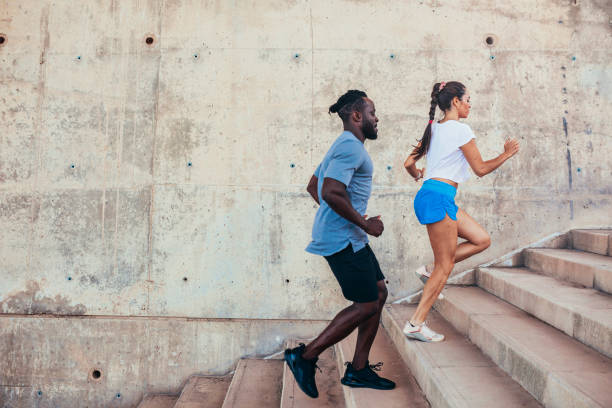 Two athletes running on stairs at urban city stock photo