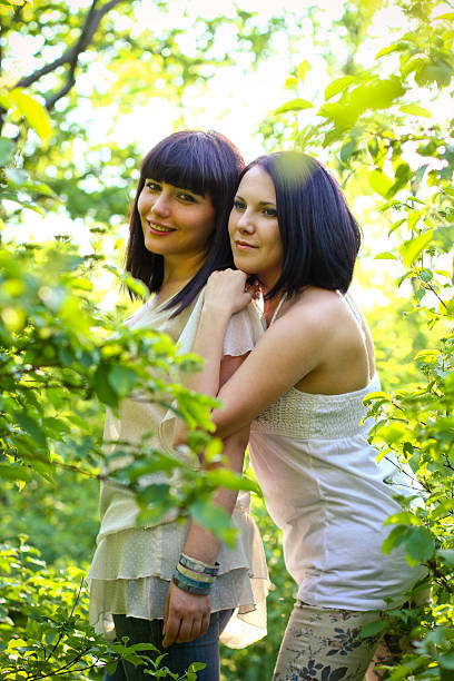 Two attractive young women posing in a summer park stock photo