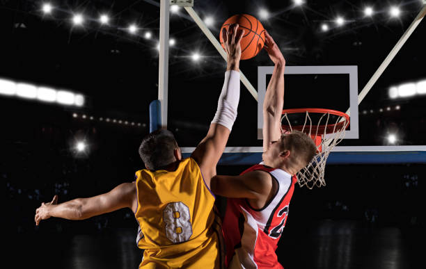 Two basketball players in arena. Blocked shot stock photo