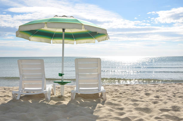 Two beach chairs and a sun umbrella stock photo