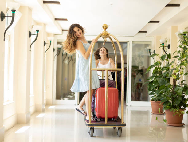 Two beautiful women using baggage cart Two beautiful women using baggage cart  ,indoor shot luggage cart stock pictures, royalty-free photos & images