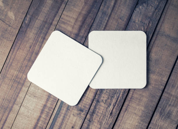 Two beer coasters Two blank square beer coasters on vintage wooden background. Flat lay. coaster stock pictures, royalty-free photos & images