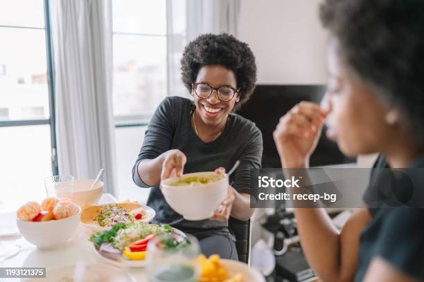 Two black women eating vegan food at home