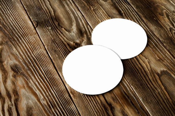 Two blank beer coasters on wooden rustic table background. Blank for new design, mock up Template for beer advertising coaster stock pictures, royalty-free photos & images