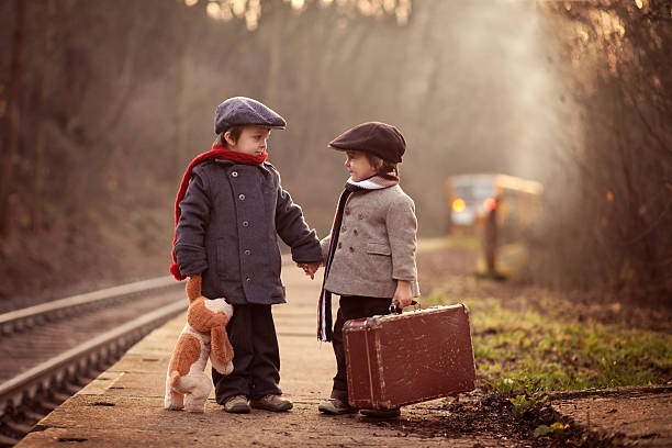 two boys on a railway station, waiting for the train - teddy ray stok fotoğraflar ve resimler