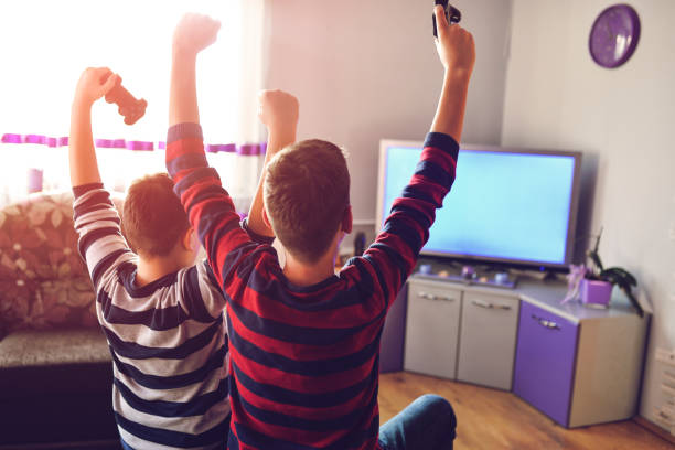 Two Boys Playing Games on TV stock photo