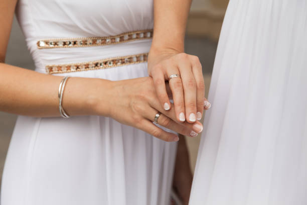 Two Brides In White Dresses Showing Wedding Rings stock photo