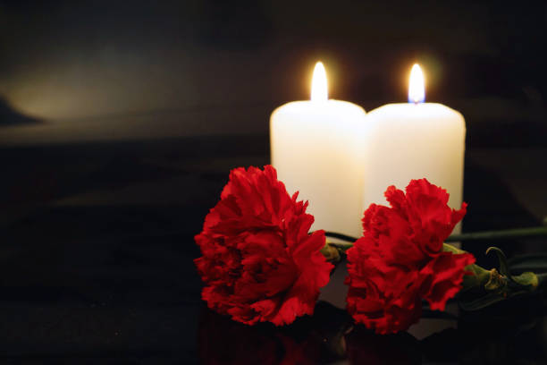 Two burning candles with flowers Two burning candles with flowers. Condolences over the bereavement. Fire of regret for irretrievable loss. cremation stock pictures, royalty-free photos & images