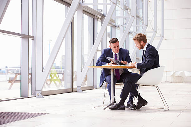 Two business colleagues at meeting in modern office interior Two business colleagues at meeting in modern office interior business relationship stock pictures, royalty-free photos & images