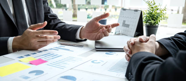 Two business partner team meeting and discussion financial project of investment ideas, presentation and analyzing marketing planning strategy of business making to growth profit and successful stock photo