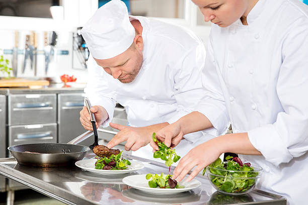 Two chefs prepares steak dish at gourmet restaurant stock photo