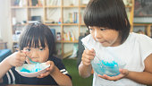 夏にかき氷を食べる 2 人の子供