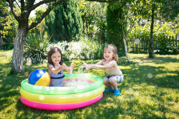 Two children having fun in inflatable swimming pool stock photo