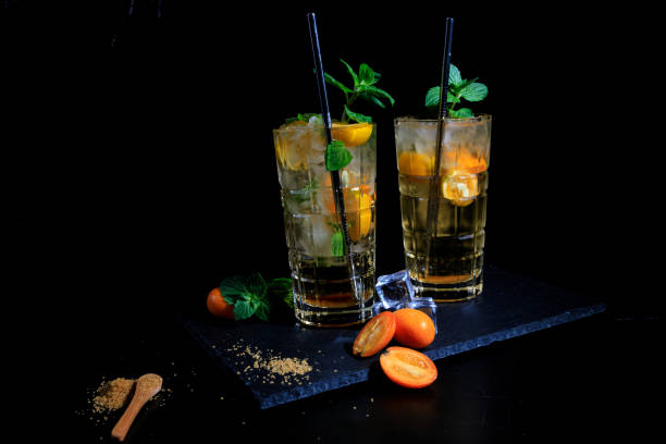 Two cocktails with kumquat on a black background stock photo