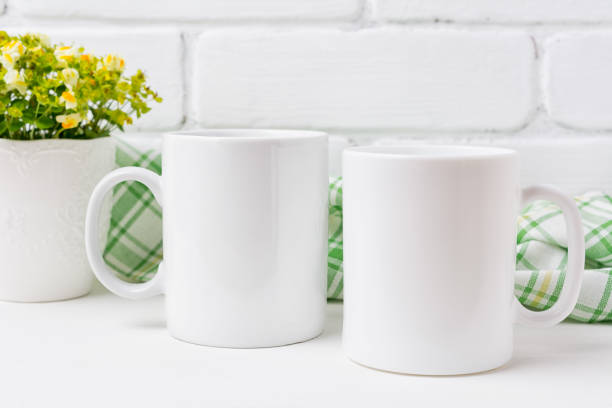 Two coffee mug mockup with yellow and green flowers Two white coffee  mug mockup with small yellow and green flowers.  Empty mug mock up for design promotion. mug stock pictures, royalty-free photos & images