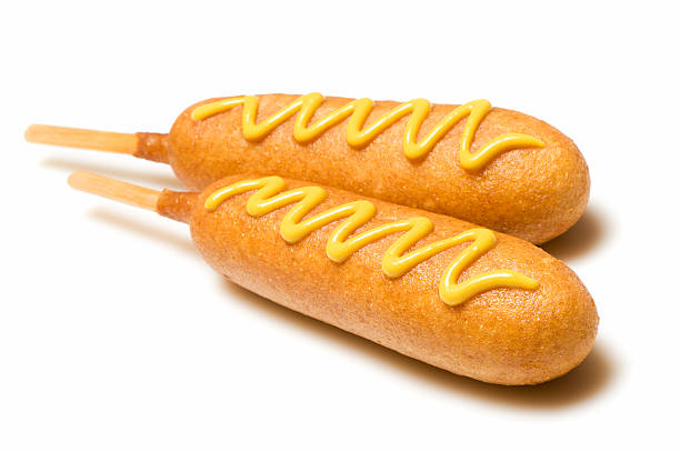 Two corn dogs with mustard isolated on white background stock photo