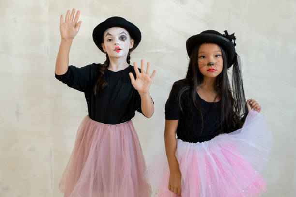 Two cute girls with halloween makeup doing pantomime Two cute girls with halloween makeup performing pantomime in front of camera mime artist stock pictures, royalty-free photos & images