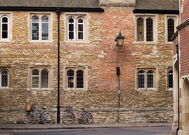 Two cycles leaning on the wall of  Trinity College, Cambridge stock photo