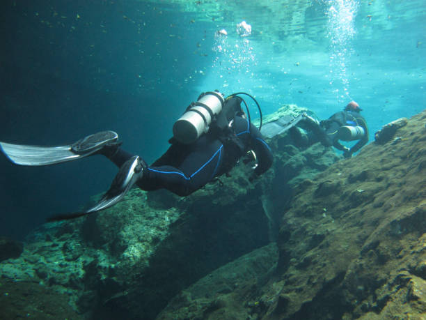 Two divers exploring the underwaters cenotes in Mexico. stock photo