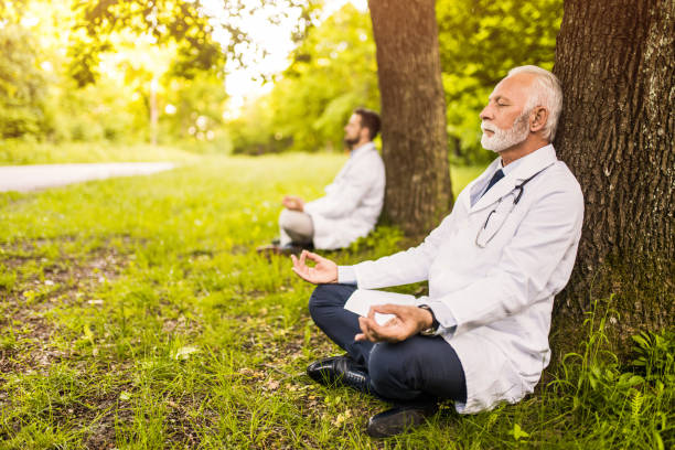 Two doctors meditating in nature. stock photo