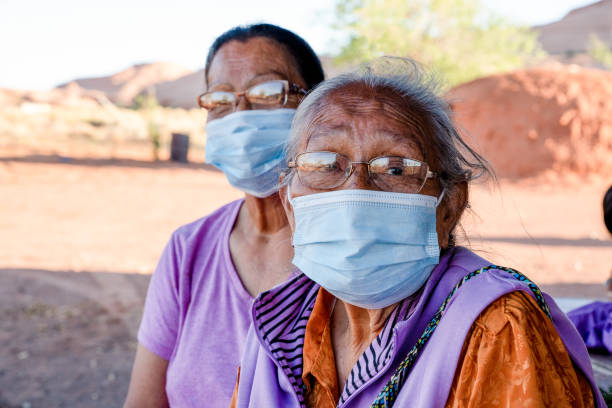 Two Elderly Navajo Women Wearing Face Masks To Protect Them From Getting The Coronavirus Two Navajo women over the age of 60 wearing masks are at high risk of contracting the Covid19 virus, Monument Valley, Navajo Nation Territory navajo culture stock pictures, royalty-free photos & images