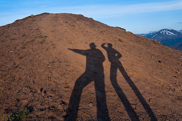 two explorers' shadows on the desert ground stock photo