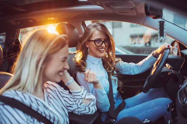 Two female friends enjoying road trip traveling at vacation in the car stock photo