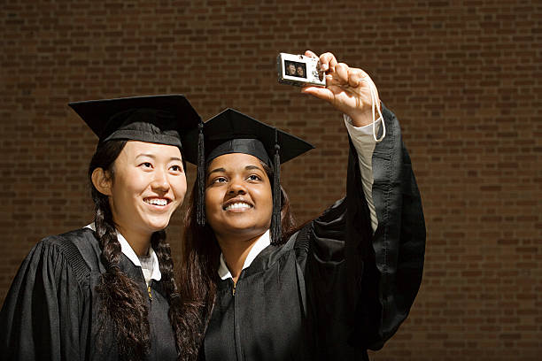 Two female graduates taking a photograph stock photo