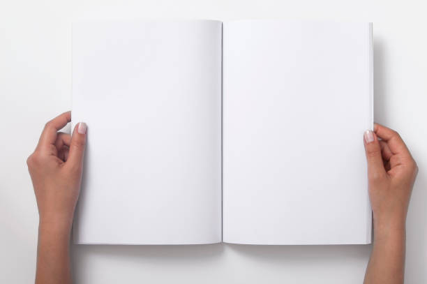 two female hands holding open a blank magazine - magazine stockfoto's en -beelden