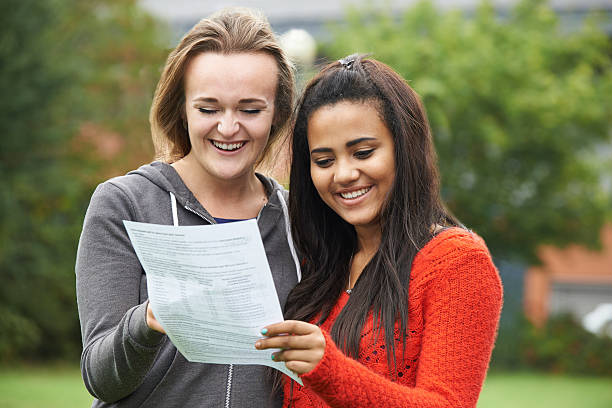 Two Female Students Celebrating Exam Results Together Two Female Students Celebrating Exam Results Together students exam results stock pictures, royalty-free photos & images