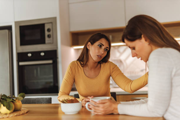 Two females discussing about life problems, while drinking coffee. stock photo