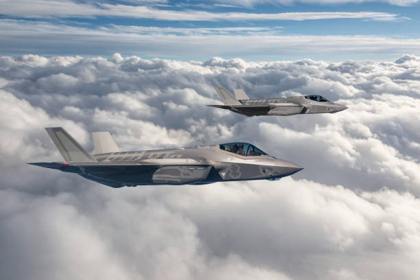 Two fighter jets flying over clouds stock photo