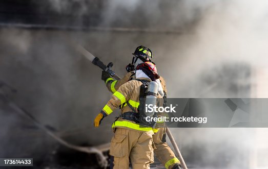 istock Two firefighters at work putting out a fire 173614433