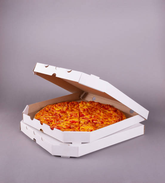 Two fragrant tasty pizzas in a box on gray background stock photo