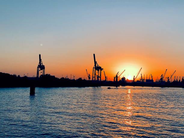 Two giraffes at sunset, cranes at the harbor II stock photo